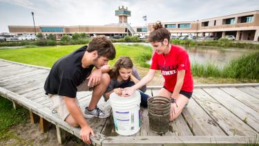 Kids looking at sea life on a dock